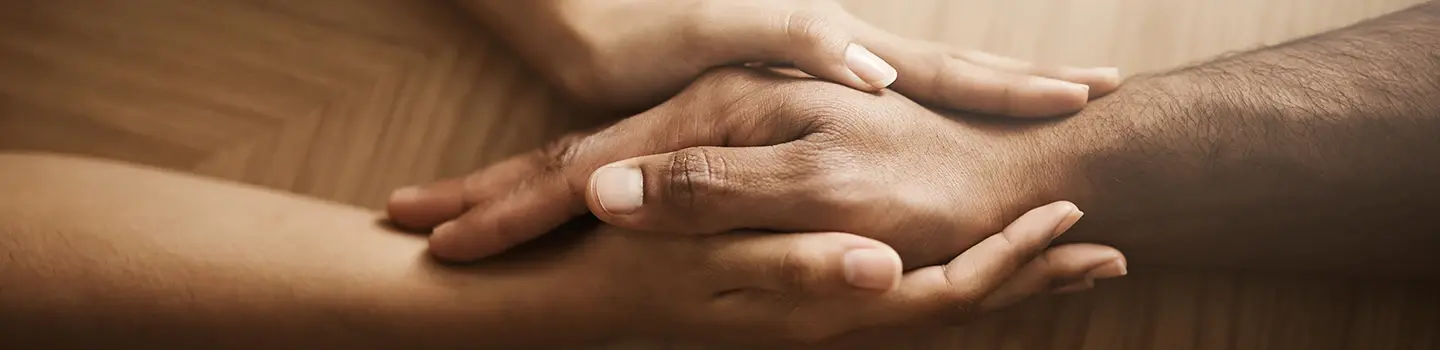 Close-up of two hands holding each other, symbolizing healing through blessings